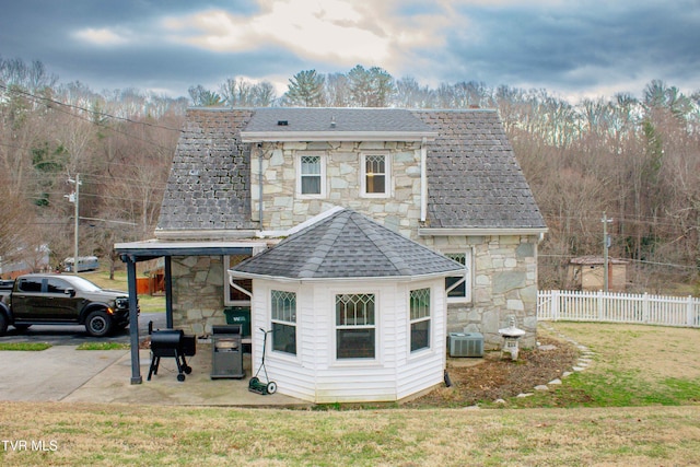 rear view of house with a patio, a lawn, and central air condition unit