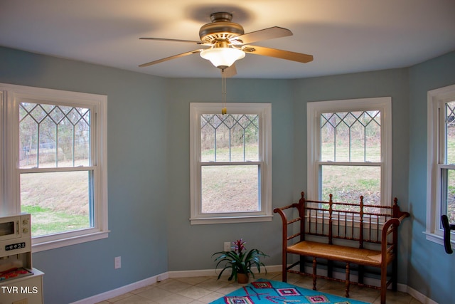 living area with light tile patterned flooring and ceiling fan