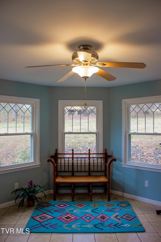 sitting room with light tile patterned floors, a healthy amount of sunlight, and ceiling fan