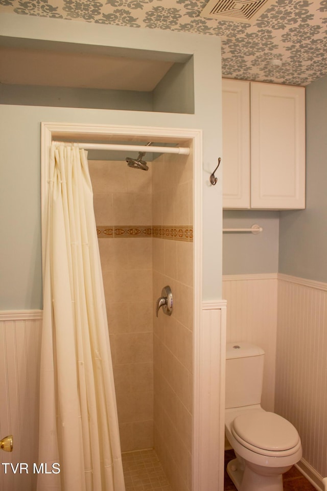 bathroom featuring toilet and curtained shower