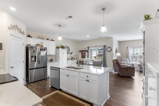 kitchen featuring white cabinetry, an island with sink, sink, hanging light fixtures, and stainless steel appliances