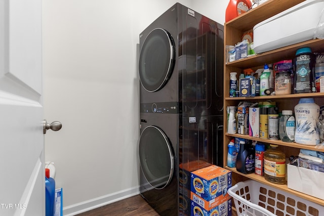 clothes washing area with dark hardwood / wood-style flooring and stacked washer / dryer