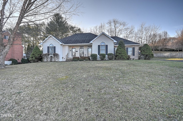 single story home with a front yard and covered porch