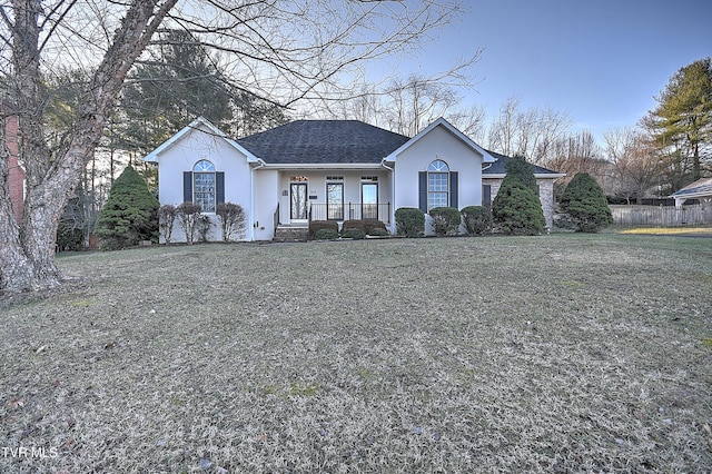 ranch-style home featuring a front lawn and covered porch