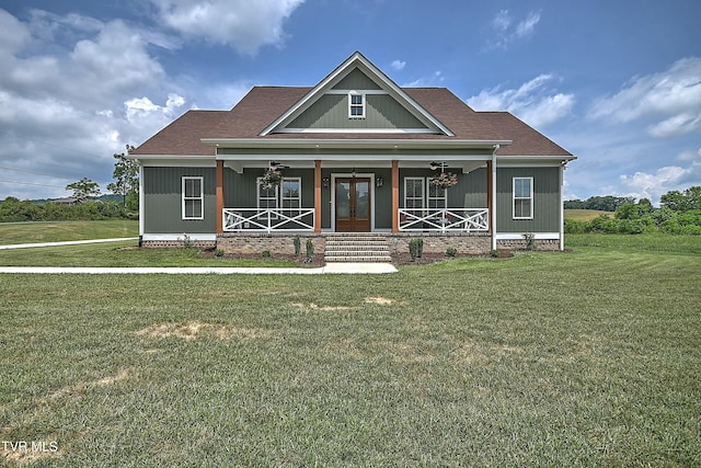 craftsman-style house featuring a front yard, covered porch, and french doors