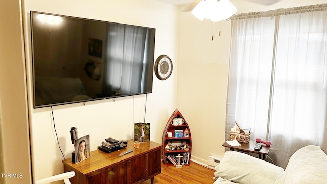 living room with light wood-type flooring and baseboard heating