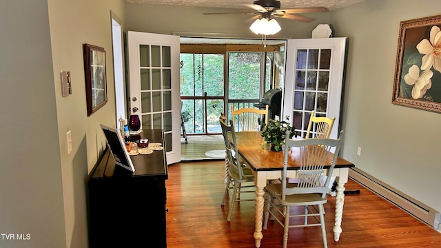 dining room featuring hardwood / wood-style floors, ceiling fan, and baseboard heating