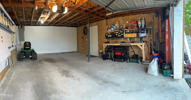 garage with a garage door opener, electric panel, and a workshop area