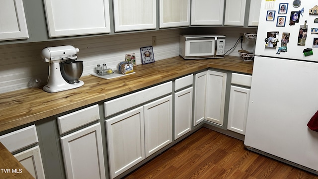 kitchen with wood counters, white appliances, dark hardwood / wood-style flooring, and white cabinets