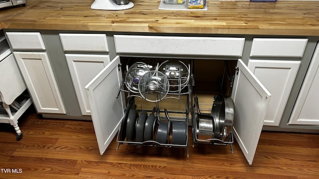 interior details with white cabinets and dark hardwood / wood-style flooring