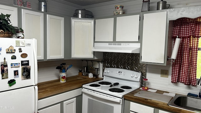 kitchen with butcher block countertops, white appliances, sink, and white cabinets