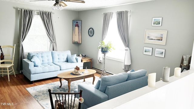 living room featuring a healthy amount of sunlight, hardwood / wood-style floors, a textured ceiling, and ceiling fan