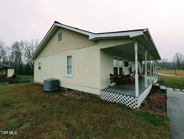 view of home's exterior with central AC unit, a yard, and covered porch