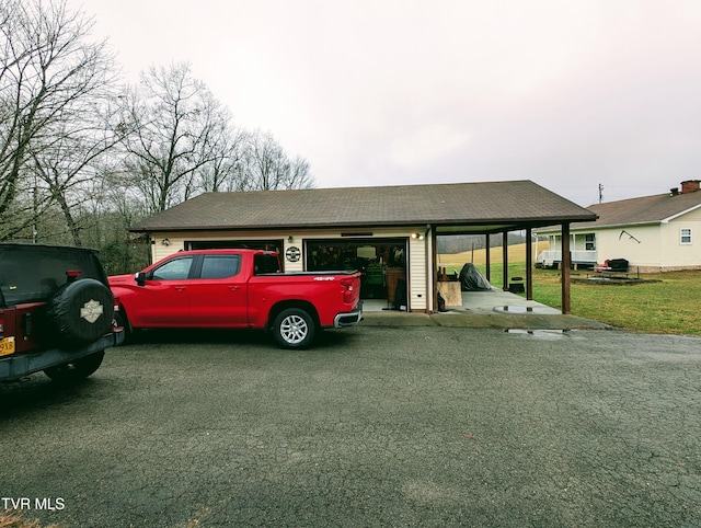 view of parking with a carport, a garage, and a yard