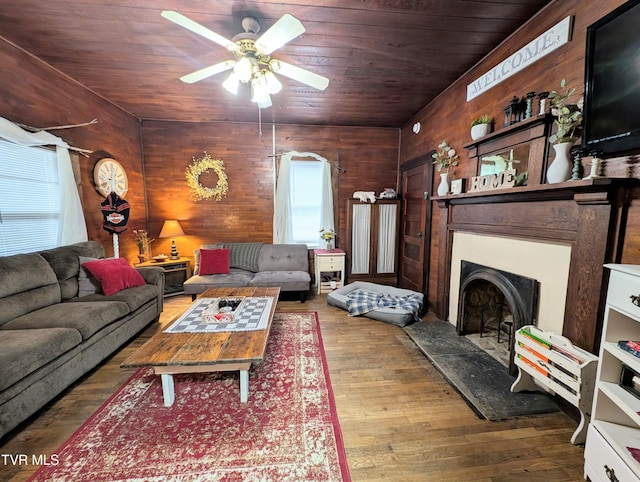 living room with wood ceiling, wood walls, ceiling fan, and hardwood / wood-style flooring