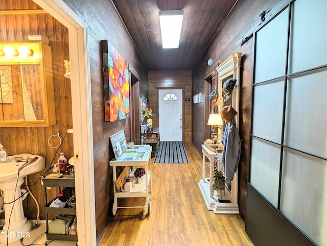 interior space featuring wooden ceiling, light hardwood / wood-style floors, and wood walls