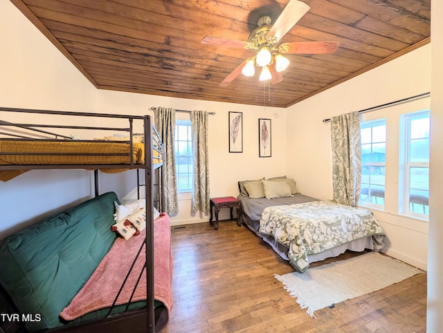 bedroom with multiple windows, hardwood / wood-style floors, wood ceiling, and crown molding