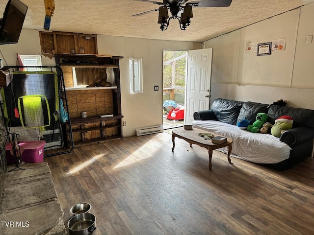 living room with dark hardwood / wood-style flooring, ceiling fan, and a textured ceiling