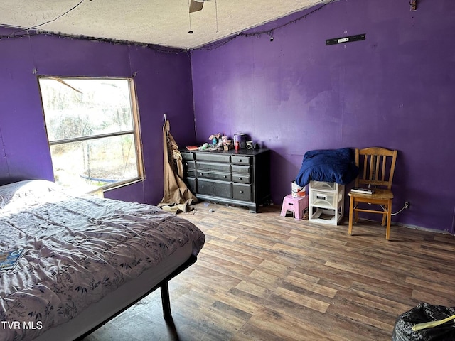 bedroom featuring hardwood / wood-style flooring, a textured ceiling, and ceiling fan