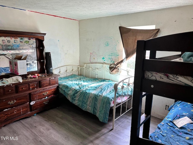 bedroom with hardwood / wood-style floors and a textured ceiling