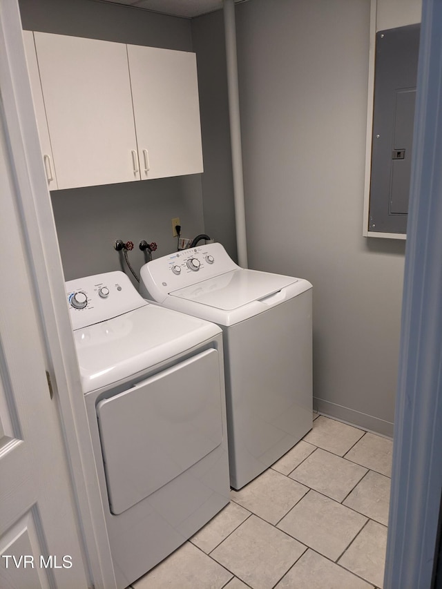 clothes washing area featuring cabinets, washing machine and dryer, light tile patterned flooring, and electric panel