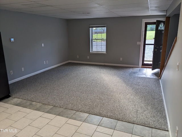 carpeted spare room featuring a drop ceiling and plenty of natural light