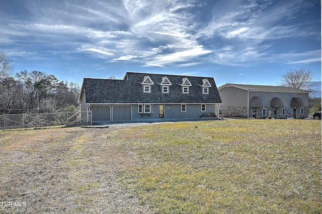 rear view of property with a garage and a lawn