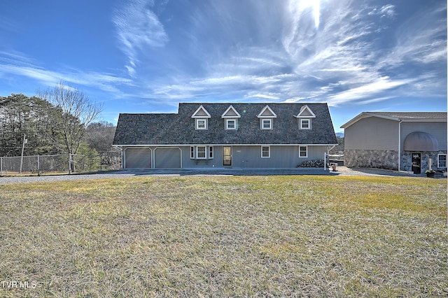 rear view of property with a garage and a yard