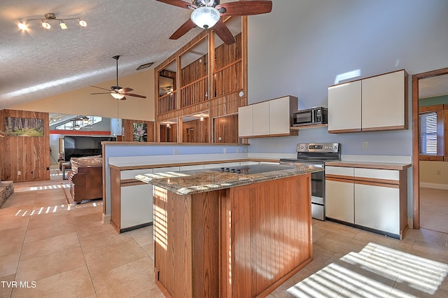 kitchen featuring light tile patterned flooring, white cabinetry, stainless steel electric range oven, a center island, and a textured ceiling