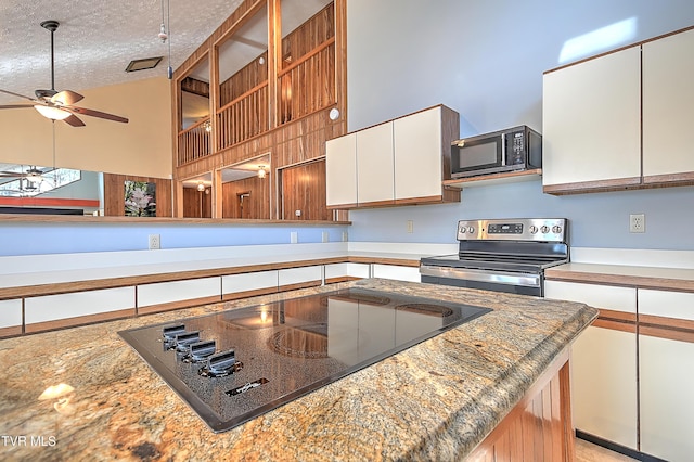 kitchen featuring a high ceiling, a textured ceiling, white cabinets, black electric cooktop, and stainless steel range with electric cooktop