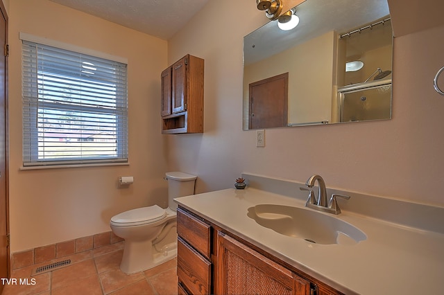 bathroom with vanity, toilet, a shower with door, and tile patterned flooring