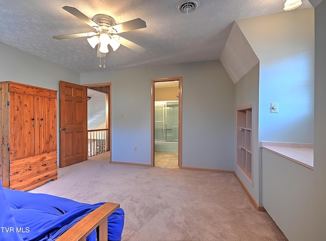 carpeted bedroom with ensuite bathroom, ceiling fan, and a textured ceiling