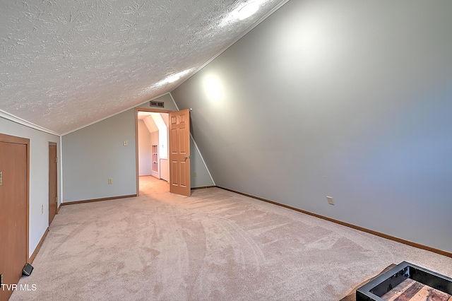 bonus room featuring lofted ceiling, light colored carpet, and a textured ceiling