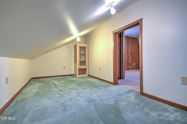 bonus room with light carpet and vaulted ceiling