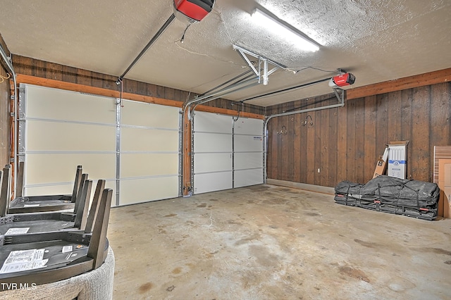 garage with a garage door opener and wooden walls