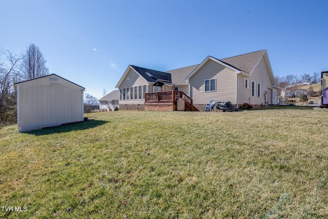 back of property featuring a wooden deck, a yard, and a storage unit