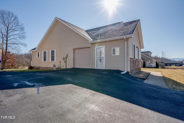 view of side of home featuring a garage and a lawn