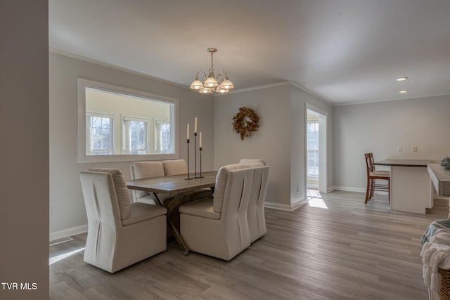 dining room featuring an inviting chandelier, crown molding, and light wood-type flooring