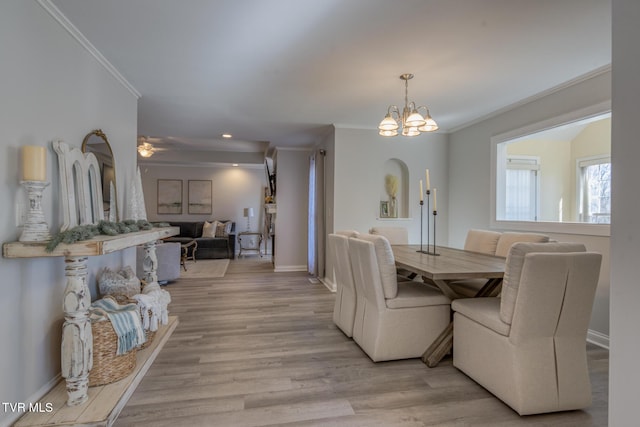 dining room featuring a notable chandelier, crown molding, and light wood-type flooring