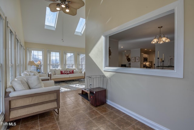 sunroom / solarium featuring ceiling fan with notable chandelier and a skylight