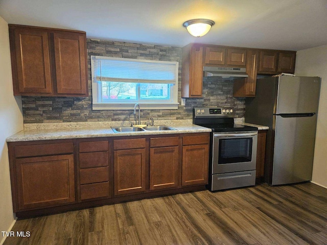 kitchen featuring dark wood-type flooring, sink, stainless steel appliances, light stone countertops, and decorative backsplash