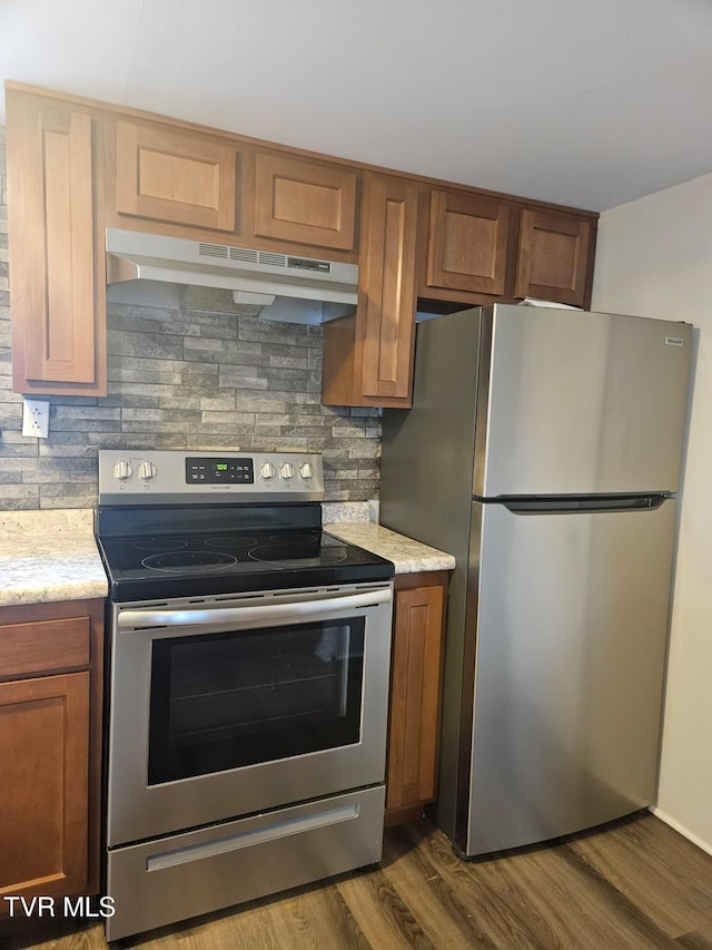 kitchen with backsplash, dark wood-type flooring, and stainless steel appliances