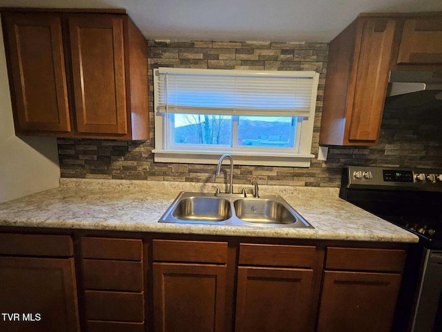 kitchen with stainless steel range with electric stovetop, sink, and backsplash