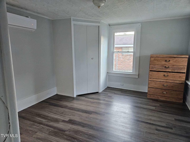 unfurnished bedroom with dark hardwood / wood-style flooring, a wall mounted air conditioner, ornamental molding, and a closet