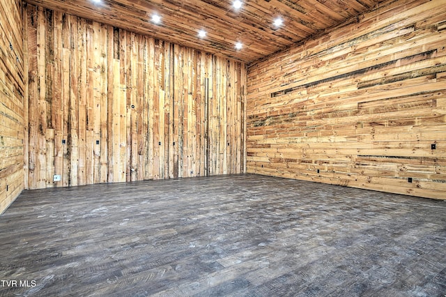 spare room featuring wood ceiling, dark wood-type flooring, and wood walls