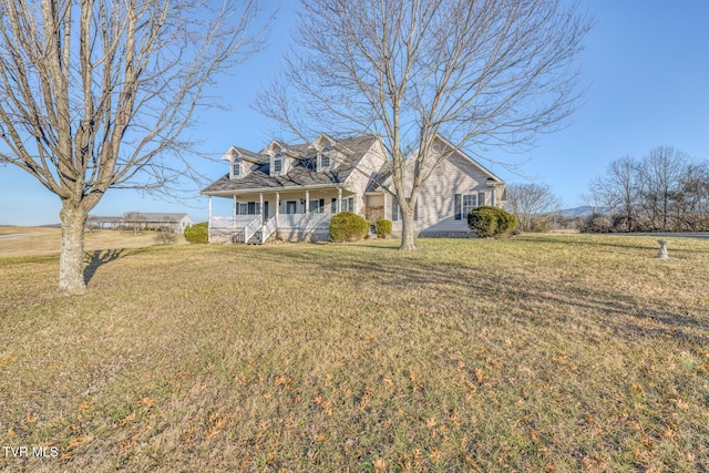 new england style home featuring a porch and a front lawn