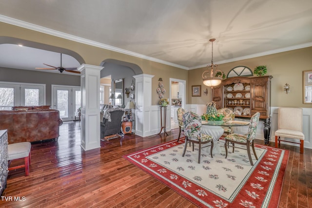 dining space with decorative columns, crown molding, dark wood-type flooring, and ceiling fan