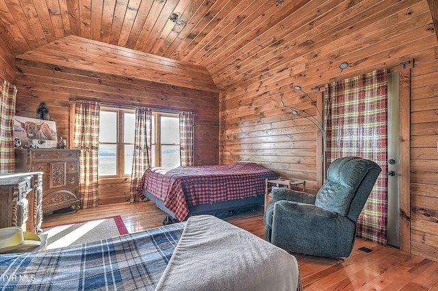 bedroom with lofted ceiling, hardwood / wood-style floors, wooden ceiling, and wood walls