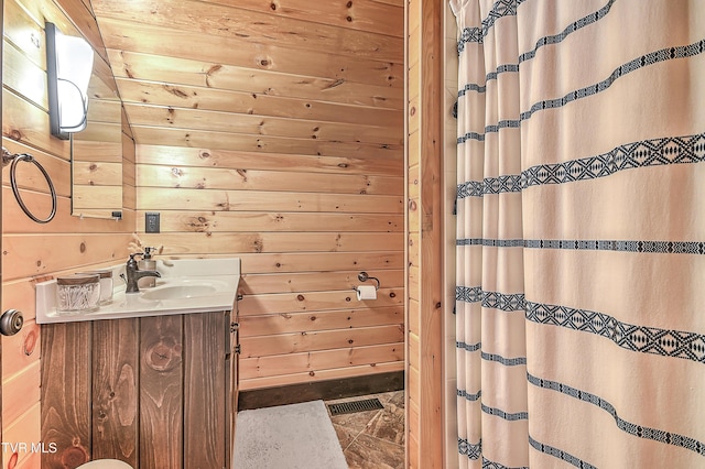 bathroom with vanity and wood walls