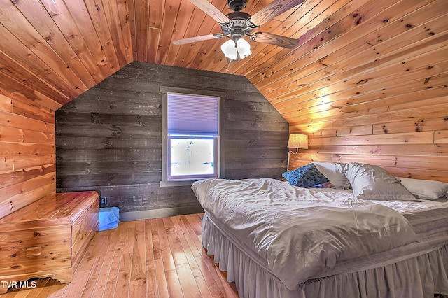 bedroom with lofted ceiling, wooden ceiling, light hardwood / wood-style floors, and wood walls